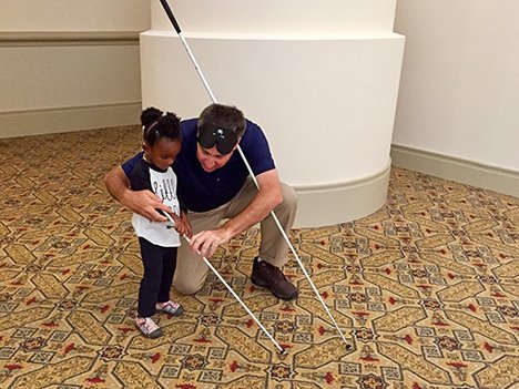 Little girl getting cane travel lesson